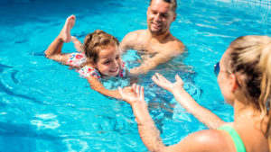 Niña aprendiendo a nadar en piscina